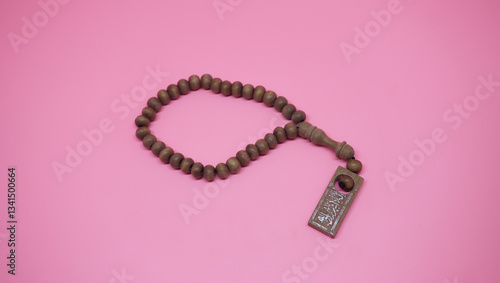 Wooden prayer beads on a pink background