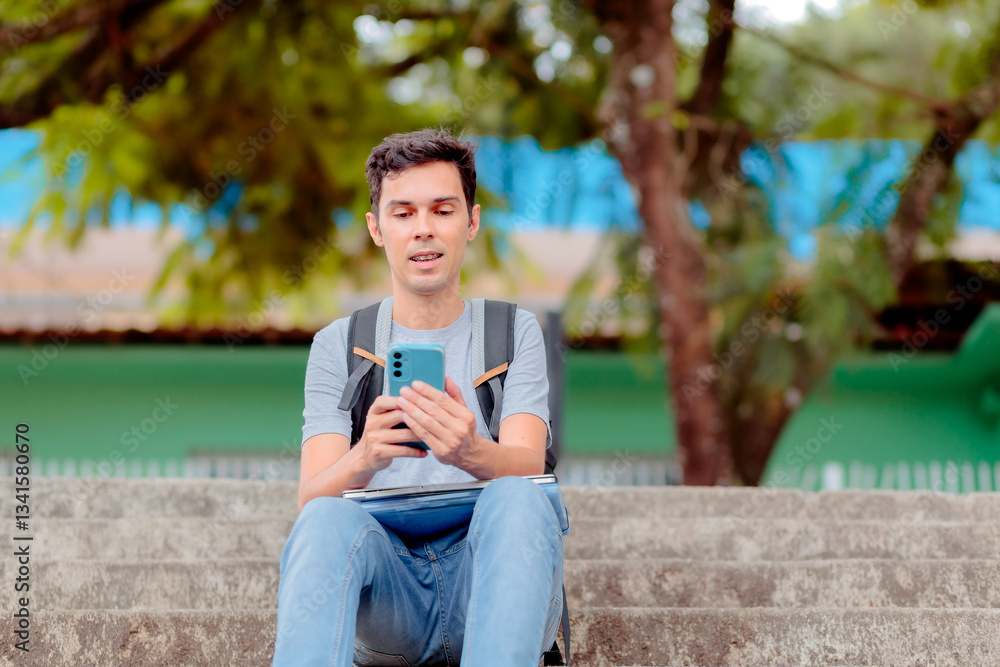 Obraz premium University student using a smartphone to get study help from an AI assistant. Young man sitting on outdoor stairs with a backpack, engaged in online learning.
