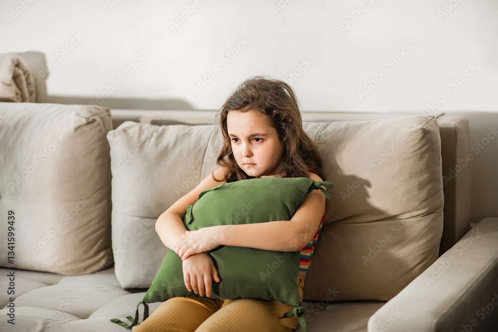 Obraz premium Child sitting alone on sofa feeling stressed unhappy, sad and depress. Little girl embracing pillow.