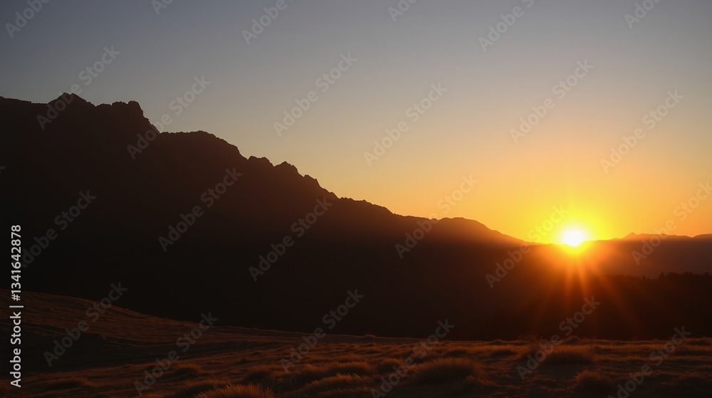 Obraz premium Breathtaking Sunrise Over Majestic Mountain Range with Silhouetted Peaks