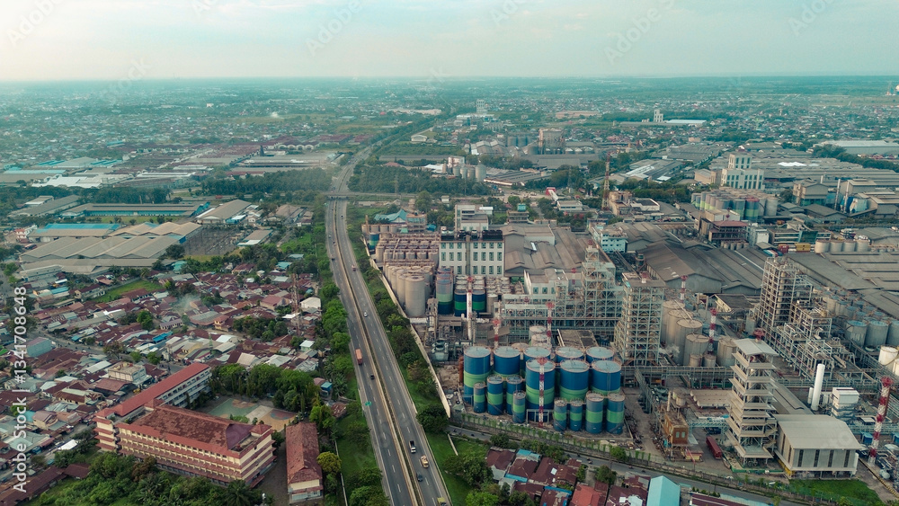 Fototapeta premium Aerial view of Medan Industrial Park, Indonesia, showcasing factories, highways, and urban development. Perfect for themes of industry, logistics, infrastructure, and economic growth