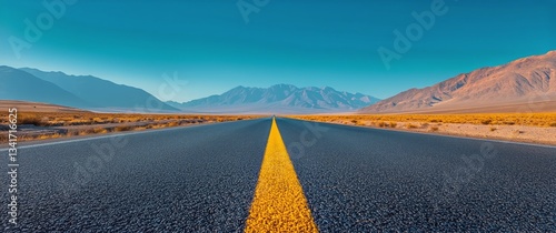Endless Road Stretches Through Desert Landscape Under Clear Blue Sky in Brigh...