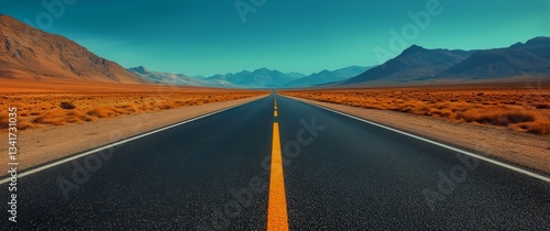 Long Empty Road Stretches Into Desert Landscape Under Clear Blue Sky