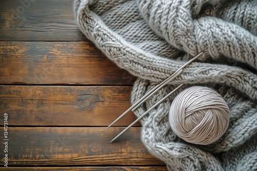 Cozy Crafting Activity With Grey Yarn and Knitting Needles on Wooden Table