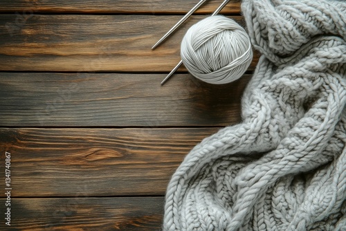 Cozy Crafting Activity With Grey Yarn and Knitting Needles on Wooden Table