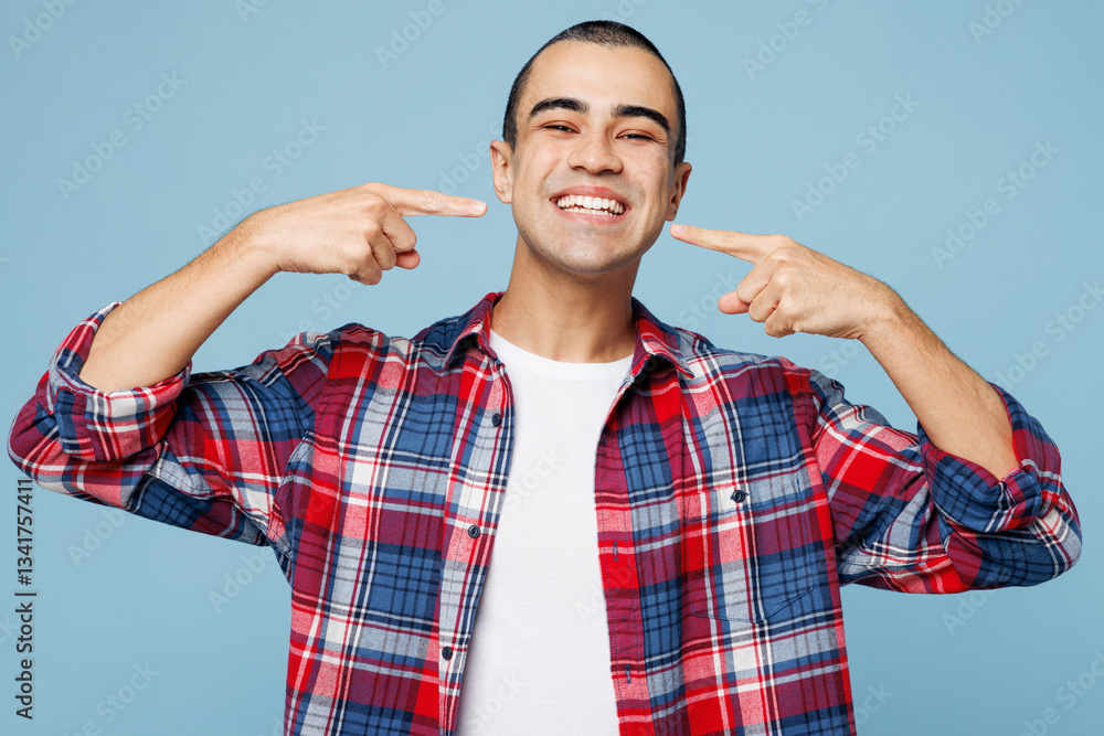 Young smiling middle eastern man wear red shirt casual clothes point index fingers on opened mouth white teeth isolated on plain pastel light blue cyan background studio portrait. Lifestyle concept Young smiling middle eastern man wear red shirt casual clothes point index fingers on opened mouth white teeth isolated on plain pastel light blue cyan background studio portrait. Lifestyle concept