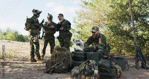Soldiers prepare for deployment, finalizing mission details, securing equipment and clothing for a forest expedition, following maps, entering data, and sending real-time updates to the base.