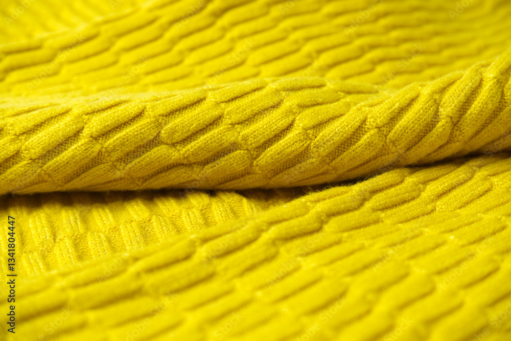 Yellow sweater texture background. Texture background of knitted clothing for winter for warm cloth, knit fabric, realistic, cozy, and crochet concepts. Close-up sweater texture with yellow-orange.
