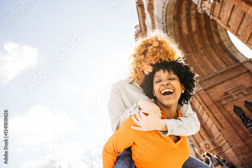 Photography Two happy women laughing and having fun in barcelona arc de triomf