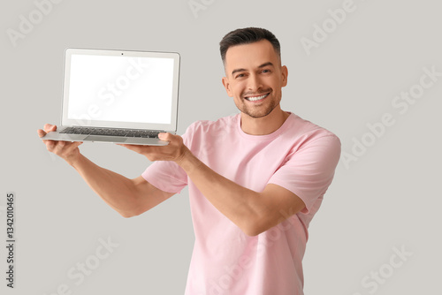 Happy young man with laptop...