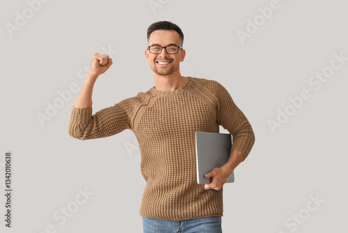 Happy young man with laptop...