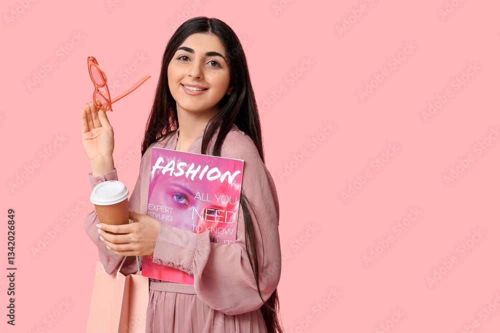 Happy smiling young woman with shopping bag, cup of coffee and magazine on pink background Happy smiling young woman with shopping bag, cup of coffee and magazine on pink background