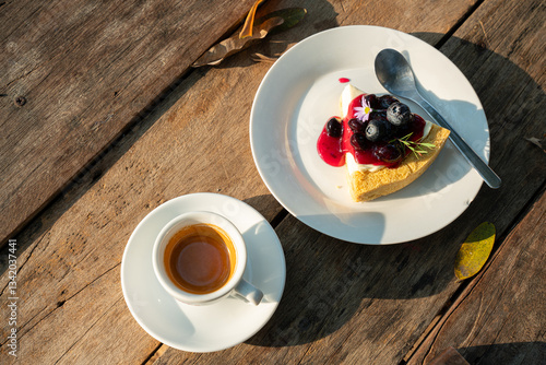 Obraz na płótnie Hot coffee espresso in cup mug and Homemade Blueberry cheesecake wood desk on wood desk on top view. As breakfast In a coffee shop at the cafe,during business work concept w salonie