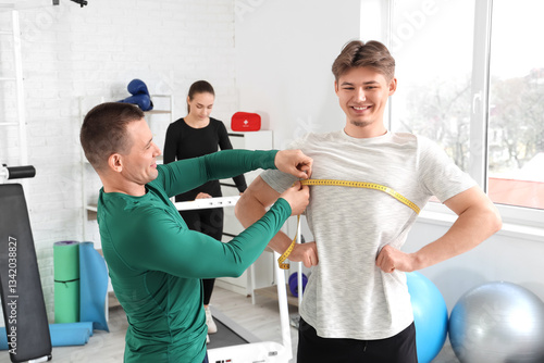 Male trainer measuring youn...