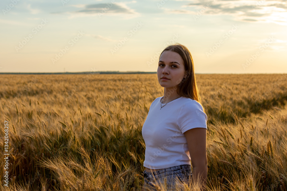 A woman in a white shirt stands gracefully in a wheat field A woman in a white shirt stands gracefully in a wheat field