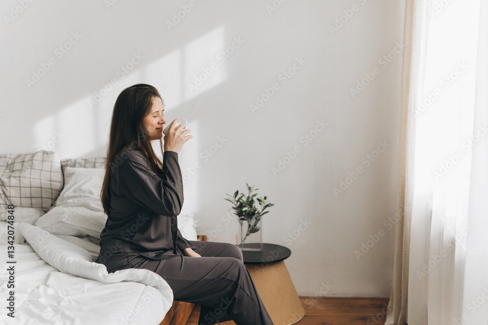 Woman enjoying morning drink in cozy bedroom setting Woman enjoying morning drink in cozy bedroom setting