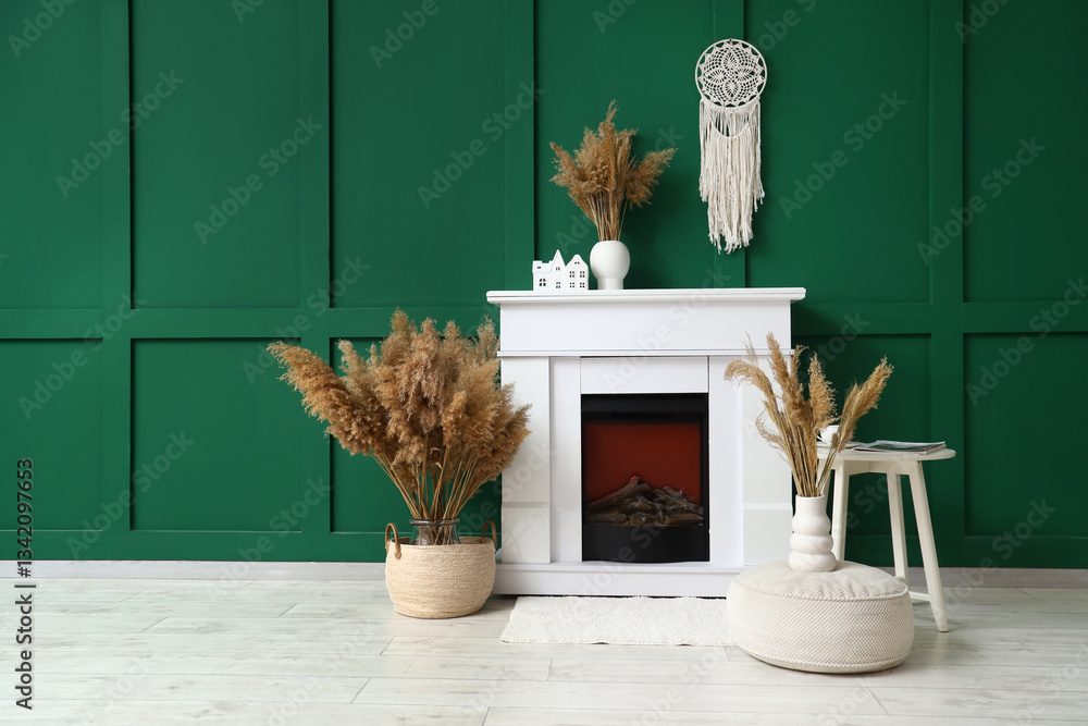 Naklejka premium Fireplace and pampas grass in vases near green wall in room