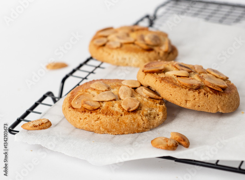 Bunch of almond cookies on a cooling tray with a white background