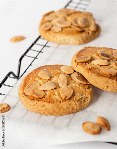 Bunch of almond cookies on a cooling tray with a white background