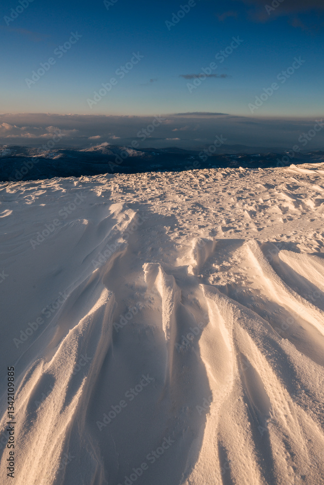 Babia Góra at sunset, covered in winter snow. A stunning mountain landscape in Babia Góra National Park, Poland. Golden light contrasts with icy peaks, creating a breathtaking view for nature and trav