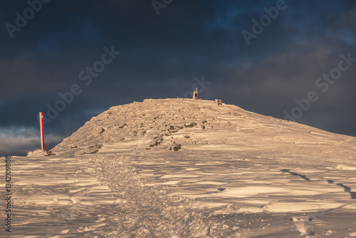 Babia Góra at sunset, covered in winter snow. A stunning mountain landscape in Babia Góra National Park, Poland. Golden light contrasts with icy peaks, creating a breathtaking view for nature and trav