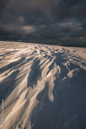 Babia Góra at sunset, covered in winter snow. A stunning mountain landscape in Babia Góra National Park, Poland. Golden light contrasts with icy peaks, creating a breathtaking view for nature and trav