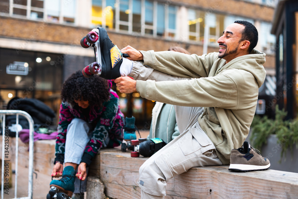 Man putting on roller skates with friends in urban setting