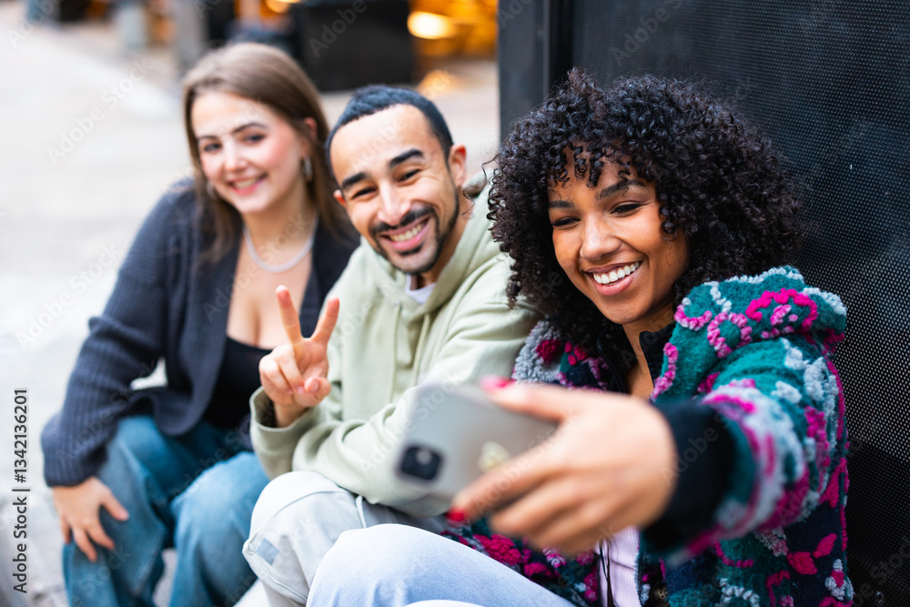 Group of happy friends taking a selfie outdoors while smiling and gesturing