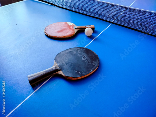 Table tennis or ping pong rackets and ball on table.