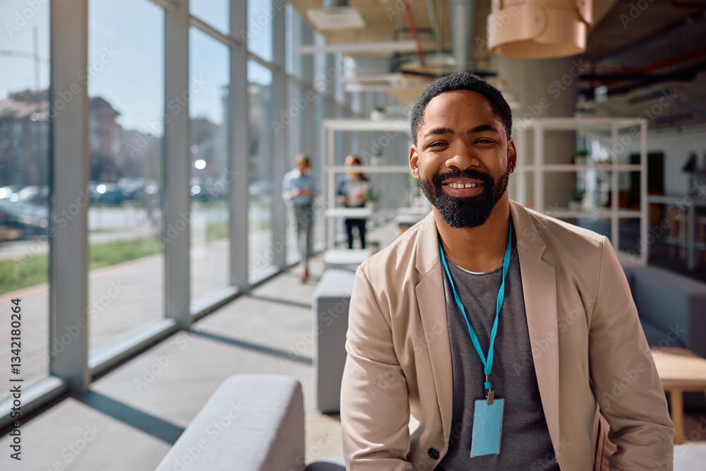 Naklejka premium Happy black businessman in office looking at camera.