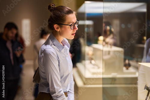 Woman wearing glasses and looking at exhibition of Museum