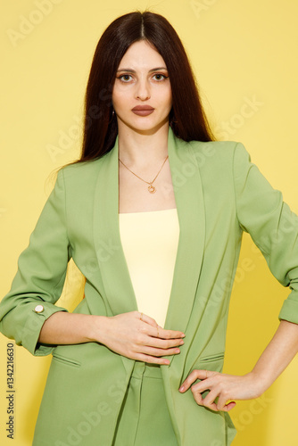 Obraz na płótnie Fashion portrait of beautiful model in green suit against yellow background w salonie