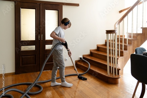 Teenager doing homework while vacuuming the stairs in a modern house on a weekday afternoon