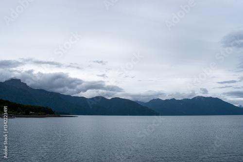 Scenic views of a lake surrounded by lush forests and rolling hills. Nature’s beauty unfolds with towering trees, serene waters, and distant mountains, creating a peaceful and pristine landscape