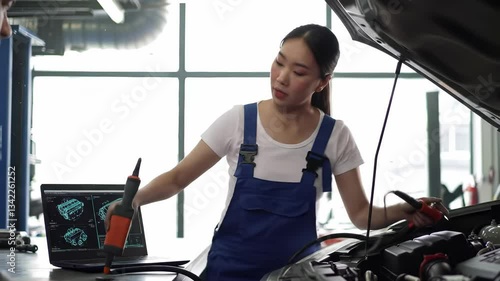 Wallpaper Mural Technician uses diagnostic equipment and a computer to troubleshoot engine problems in an automotive repair shop. Bright workspace and advanced technology are visible. Torontodigital.ca