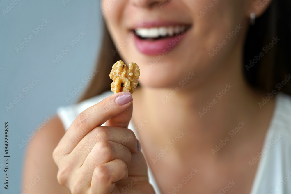 Close-up of young woman showing a walnut