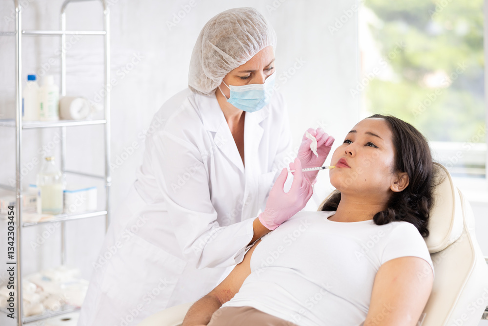 Naklejka premium Professional cosmetologist injecting the medication under patient skin in procedure cabinet