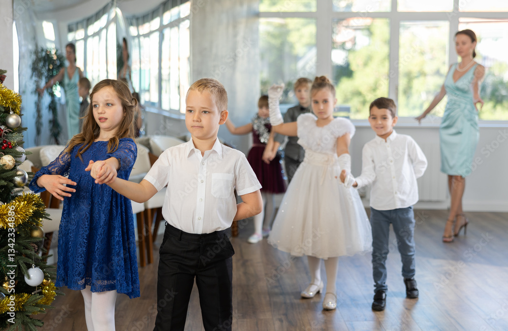 Christmas ball - group of children in festive clothes dances a waltz around the New Year tree Christmas ball - group of children in festive clothes dances a waltz around the New Year tree