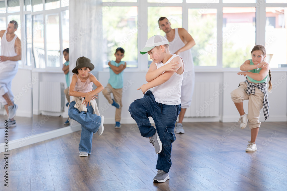 Fototapeta premium Positive girls and boys training hip hop in dance studio, dance classes for kids