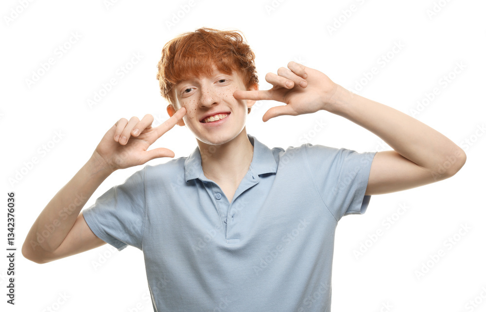 Smiling teenage boy pointing at his freckles on white background Smiling teenage boy pointing at his freckles on white background