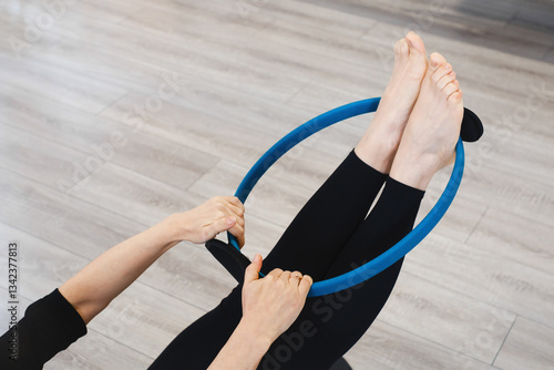 Using flix ring for practicing pilates. Pilates toning exercises for abs with flex ring toner, Hands and legs using pilates circle in a yoga studio. Training and sport activities for adults. Closeup
