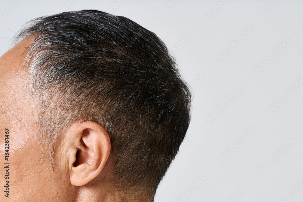Obraz premium 私服姿のシニア男性の耳元