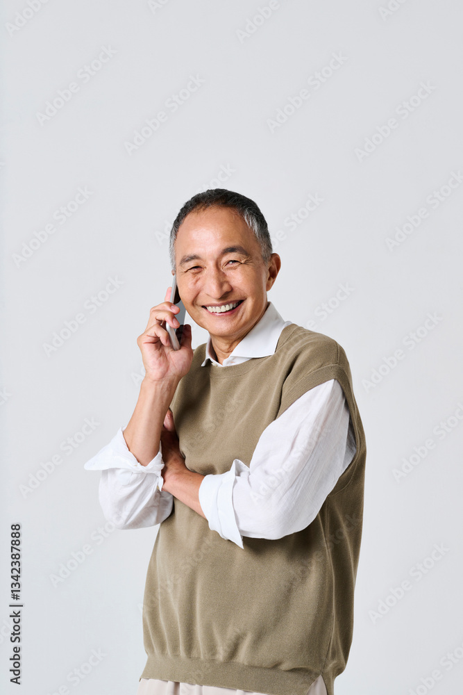 スマートフォンで通話をする私服姿のシニア男性
