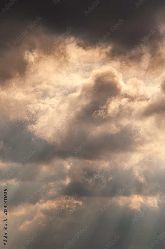 large white thunderclouds with bright rays of sunlight breaking through them large white thunderclouds with bright rays of sunlight breaking through them