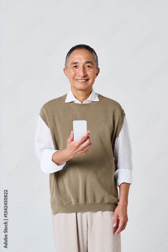 スマートフォンを使う私服姿のシニア男性 スマートフォンを使う私服姿のシニア男性