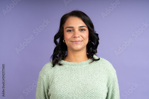 Confident latin woman smiling on purple background