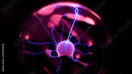 Close Up of a Plasma Globe Lamp With A Hand Pressed Against the Glass Orb