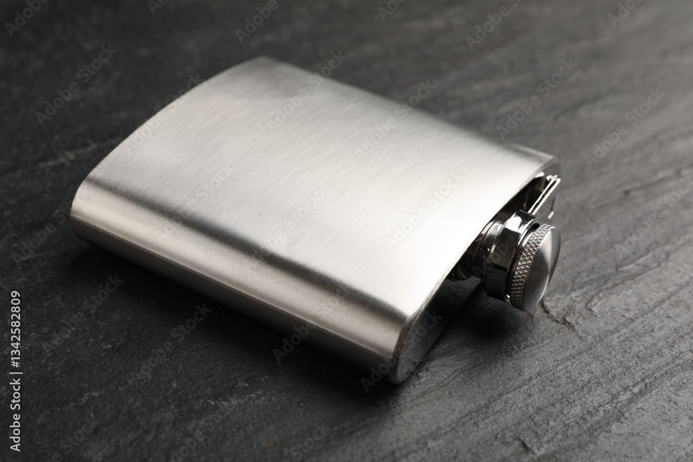 One hip flask on black table, closeup One hip flask on black table, closeup