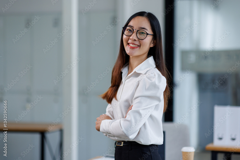 Smiling business asian woman using laptop at work document sitting in office, looking at camera.
Smiling business asian woman using laptop at work document sitting in office, looking at camera.