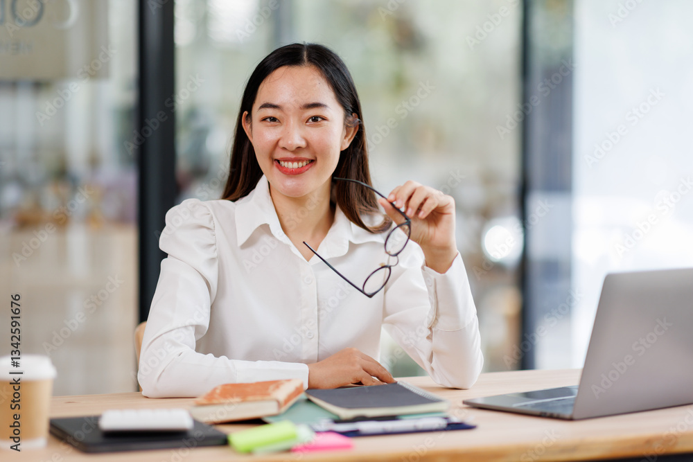 Smiling business asian woman using laptop at work document sitting in the office, Smiling business asian woman using laptop at work document sitting in the office,
